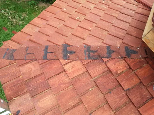 Grate geschützt durch eine Schicht aus geklebten und genagelten Bitumenschindeln